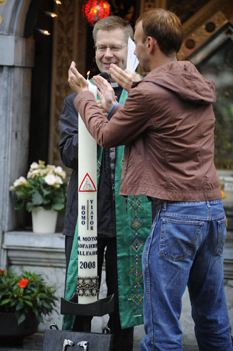 Foto zeigt Pastor Zekorn beim Anzünden der Pilgerkerze.